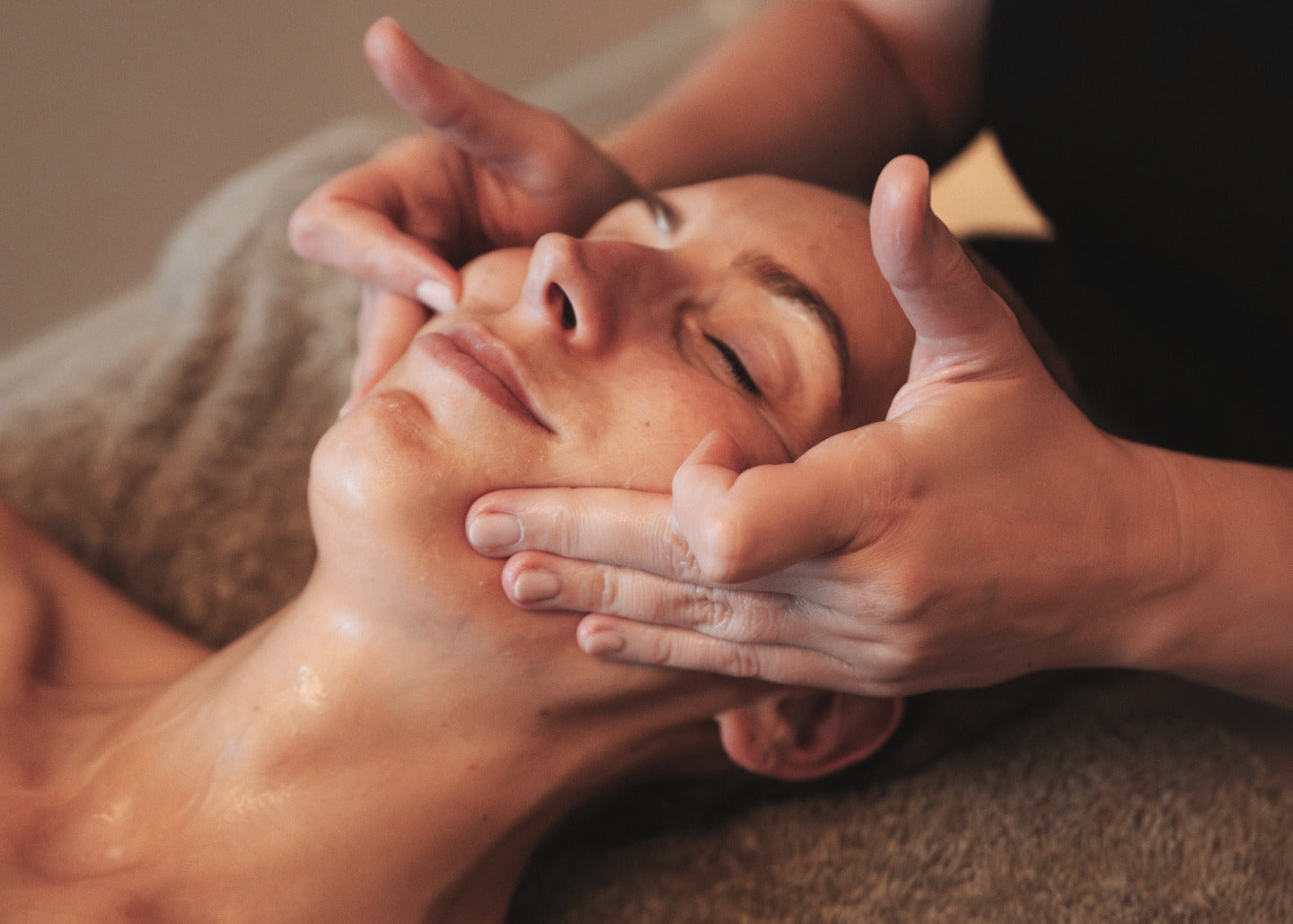 Person receiving a facial massage in a spa setting